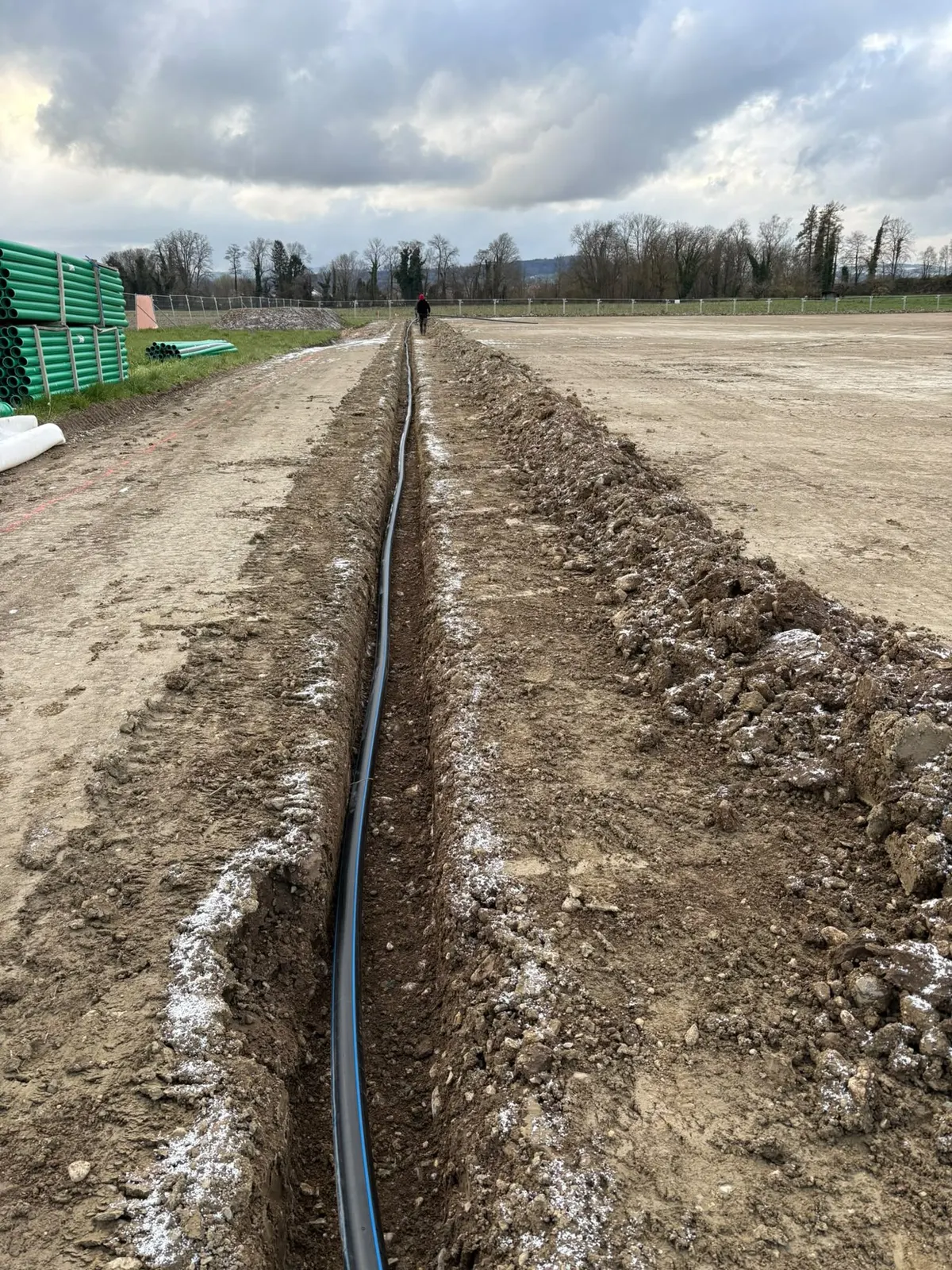 Tranchée rectiligne avec conduite d’arrosage dans un champ en cours d’aménagement